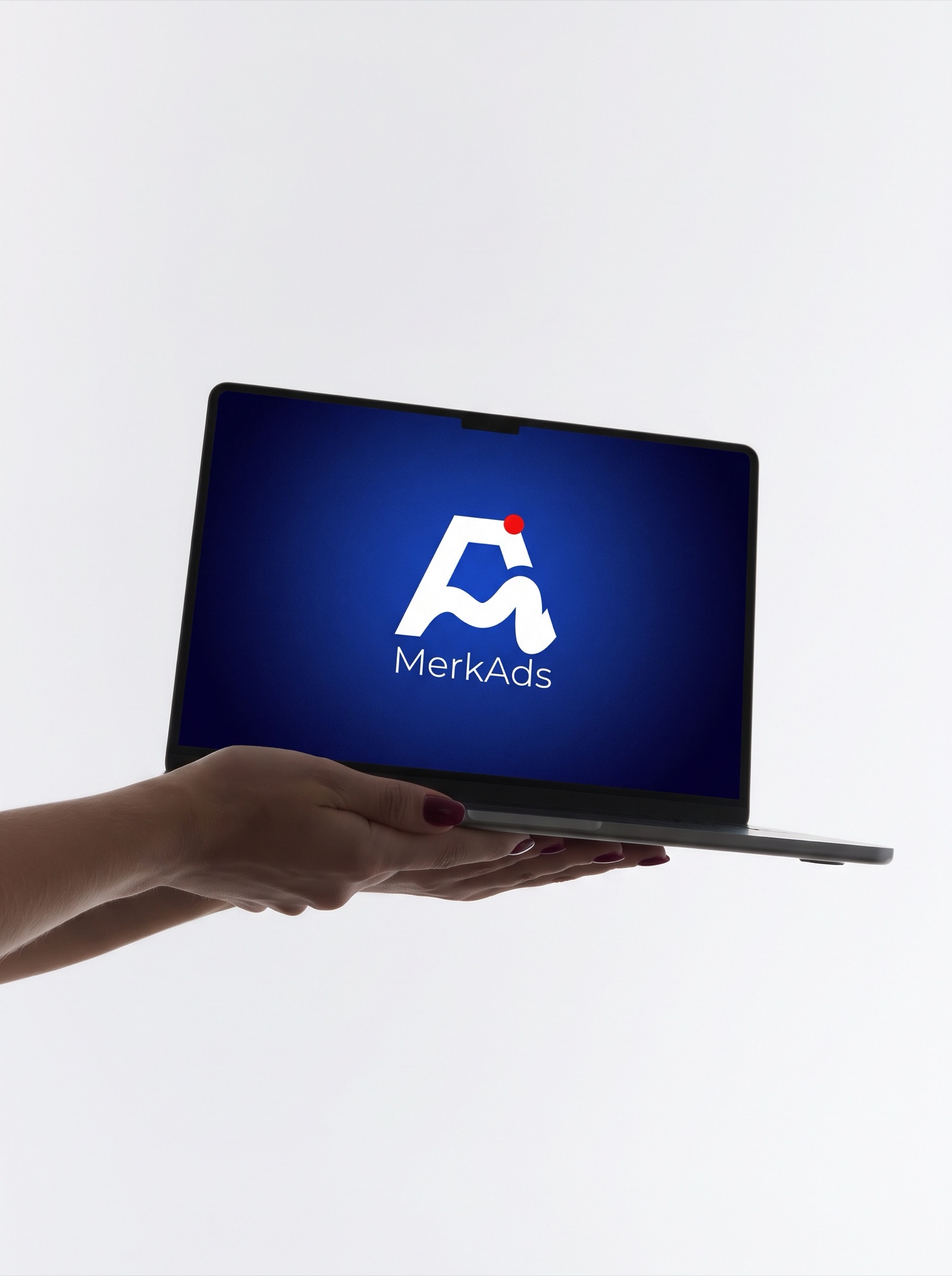Mano sosteniendo una laptop abierta con el logotipo de Merkads en la pantalla